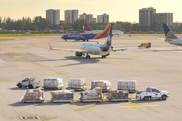 マイアミ国際空港で航空貨物パレットを積んだ小型トラック牽引トレーラー - us fba air express ストックフォトと画像