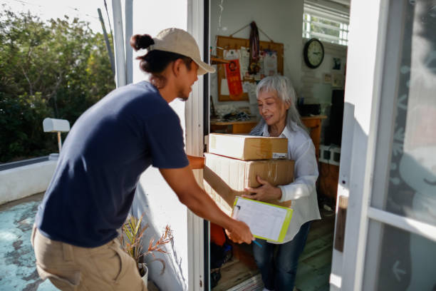 祖母はクリスマスに宅配便の荷物を受け取った - door-to-door international shipping ストックフォトと画像